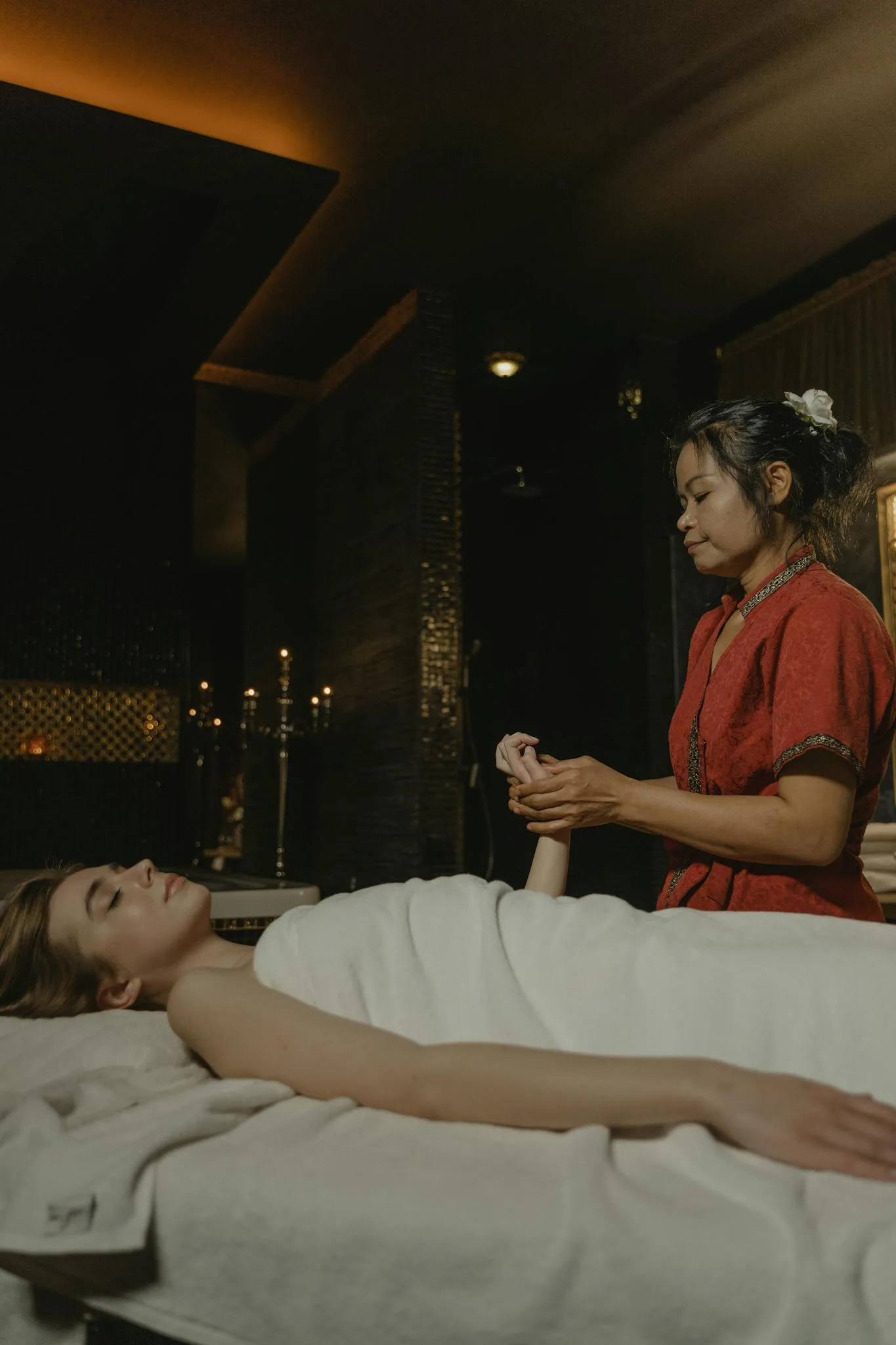 Woman receives a calming massage in a serene spa setting, enhancing relaxation and wellbeing.